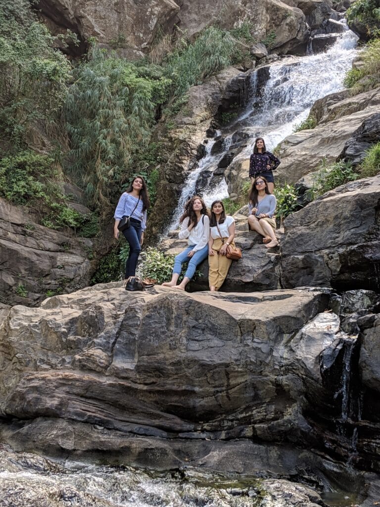 Girls standing in front of Ravana Waterfall in Ella 