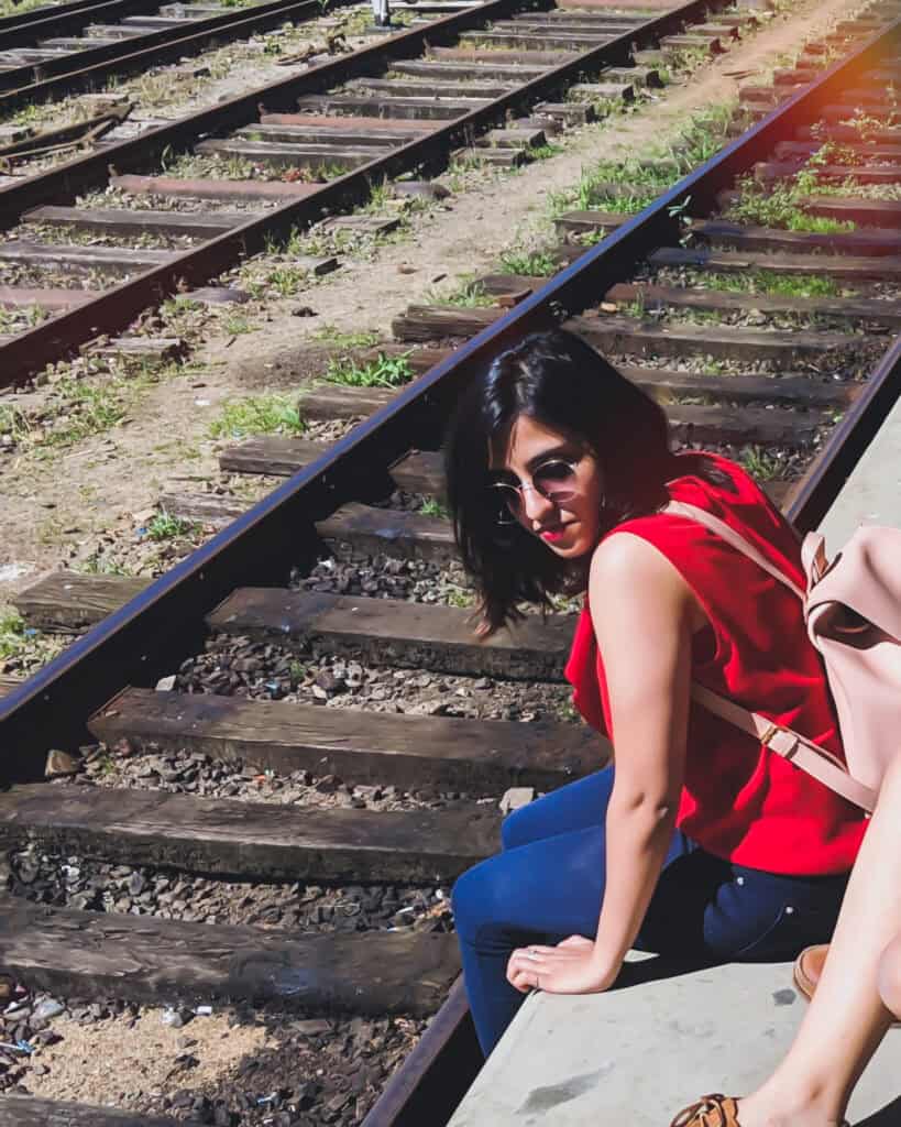 Girl sitting next to train tracks