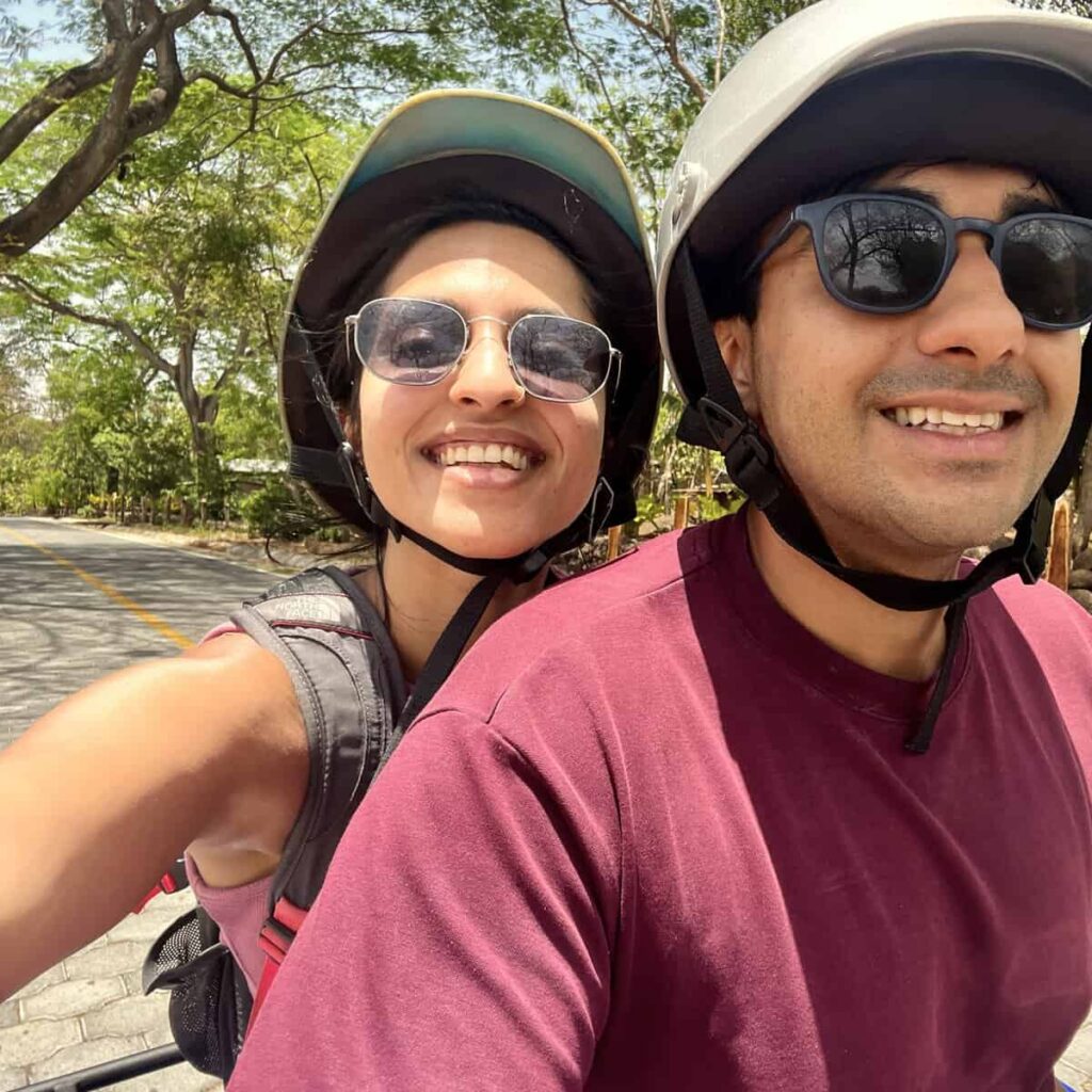Couple sitting on an ATV in Ometepe, Nicaragua, surrounded by lush greenery.