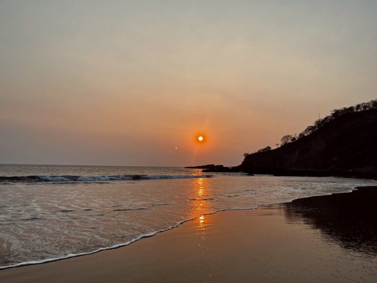 Golden sunset over the beach in San Juan del Sur, Nicaragua, with gentle waves.
