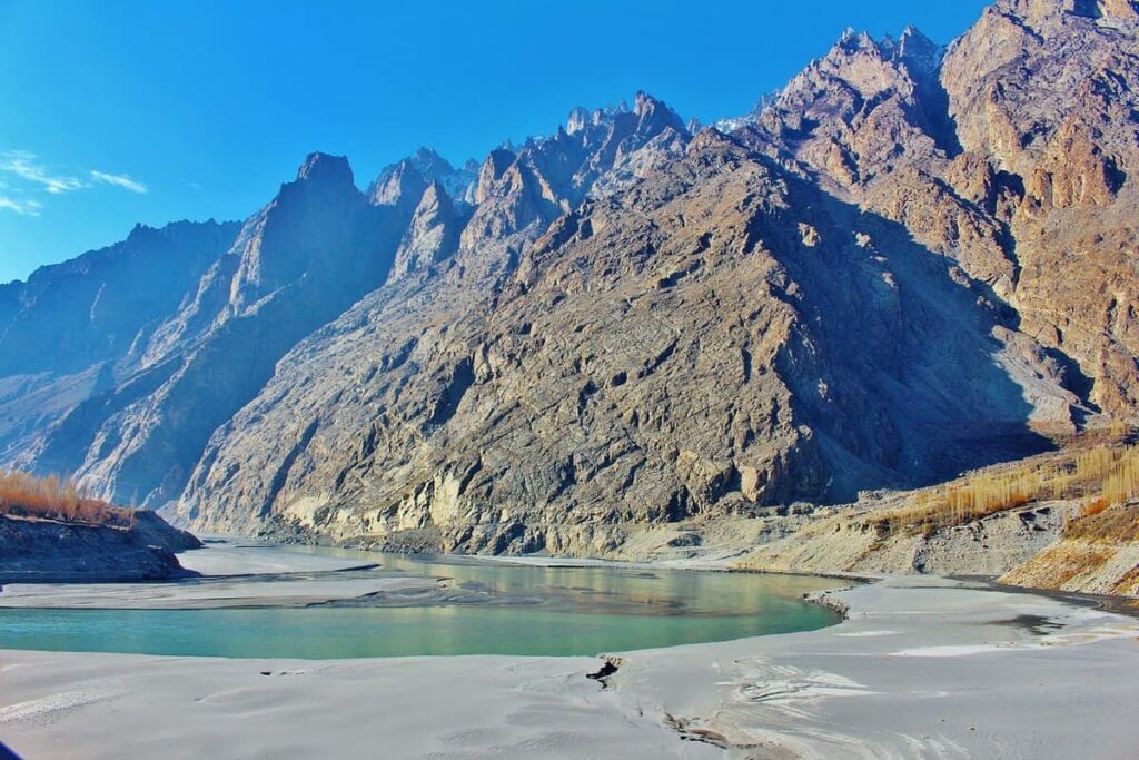 Hunza river with mountains in the backdrop and clear blue skies