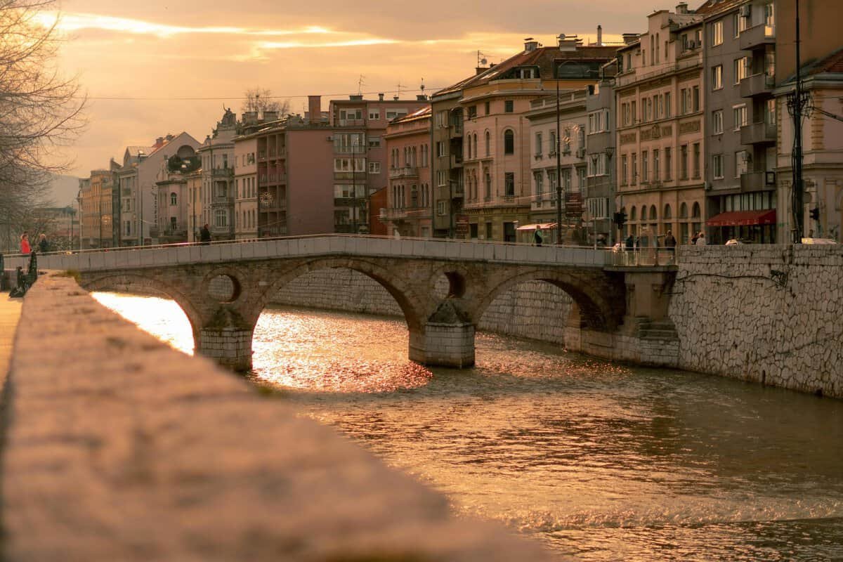 Historic view of the Latin Bridge in Sarajevo, Bosnia and Herzegovina — an Ottoman-era stone bridge arching over the Miljacka River, known as the site of Archduke Franz Ferdinand’s assassination in 1914.