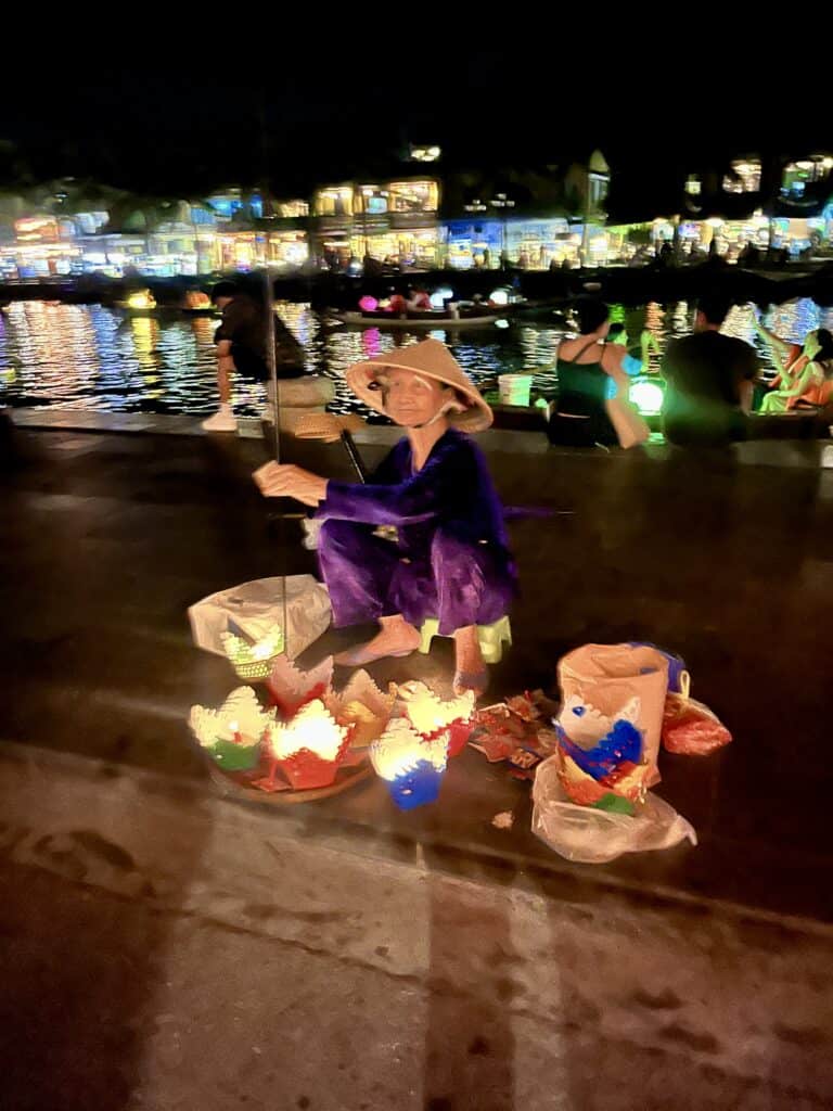 A woman selling lanterns on the sidewalk.