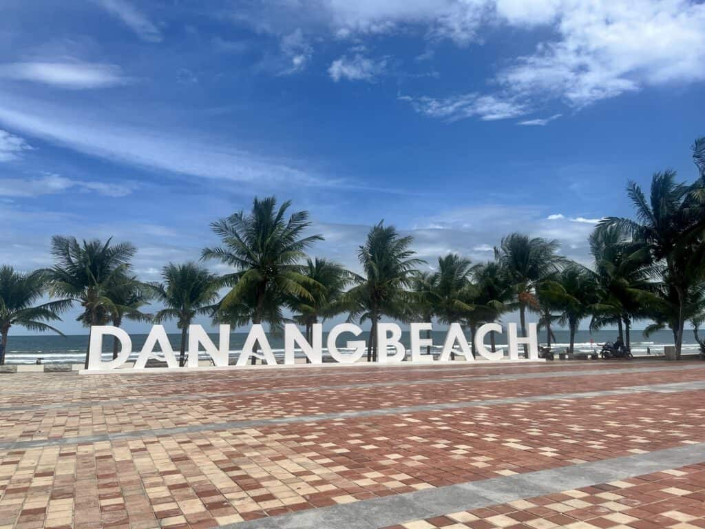 Danang Beaches sign board with palm trees in the background