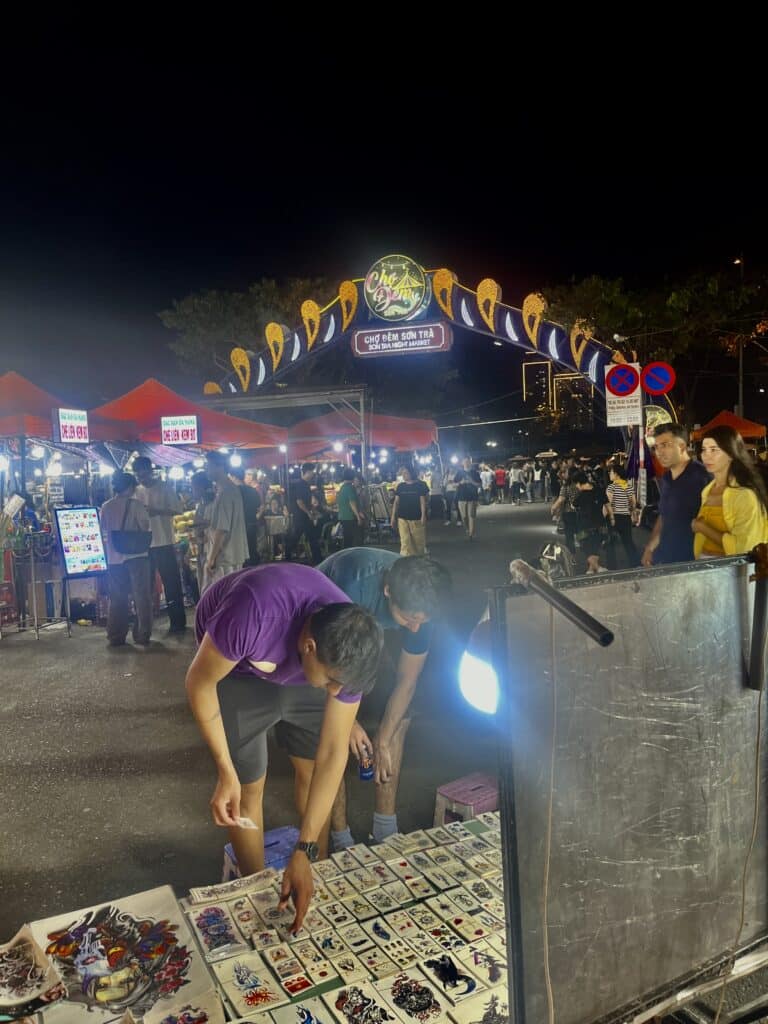 2 men picking tattoos from a temporary tatoo stand