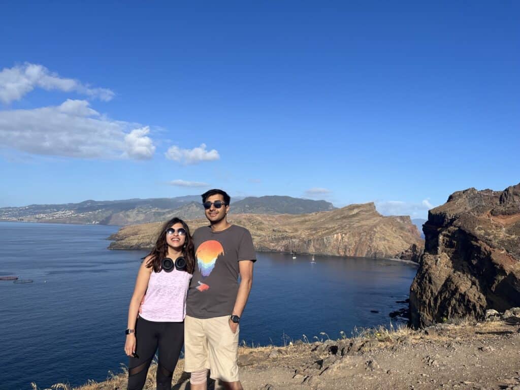 A couple standing on a cliff on the Eastern End of Madeira island, with the ocean in the back