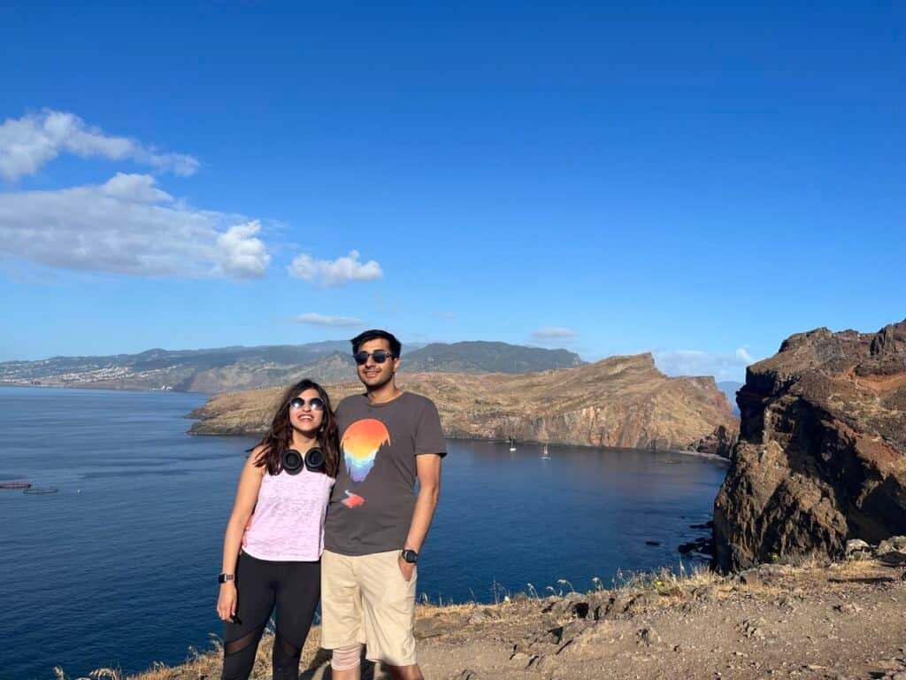 A couple standing on a cliff in Madeira, Portugal on a bright sunny day.