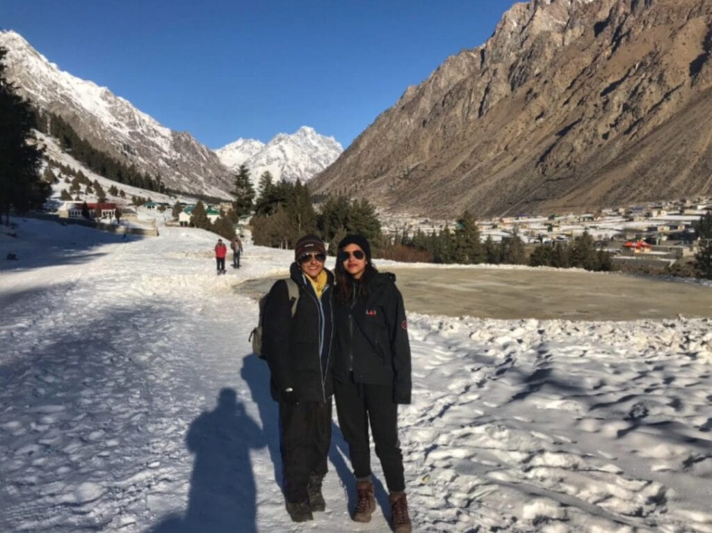 2 girls standing at the edge of a ski slope in Naltar