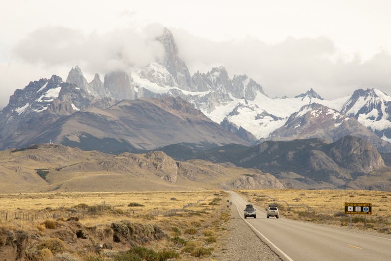 A stunning landscape of Patagonia, featuring rugged mountains and a clear blue sky, setting the stage for an adventure in El Calafate and El Chaltén.