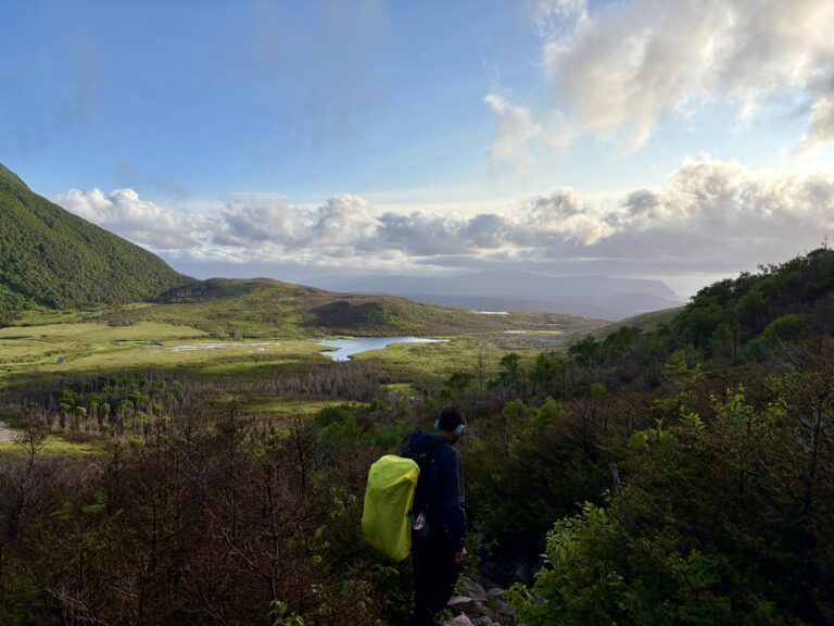 View from the descent at Ferry Gulch, with a wide valley bathed in golden light from the setting sun, though the sun itself is out of frame. A dramatic end to the Long Range Traverse day.