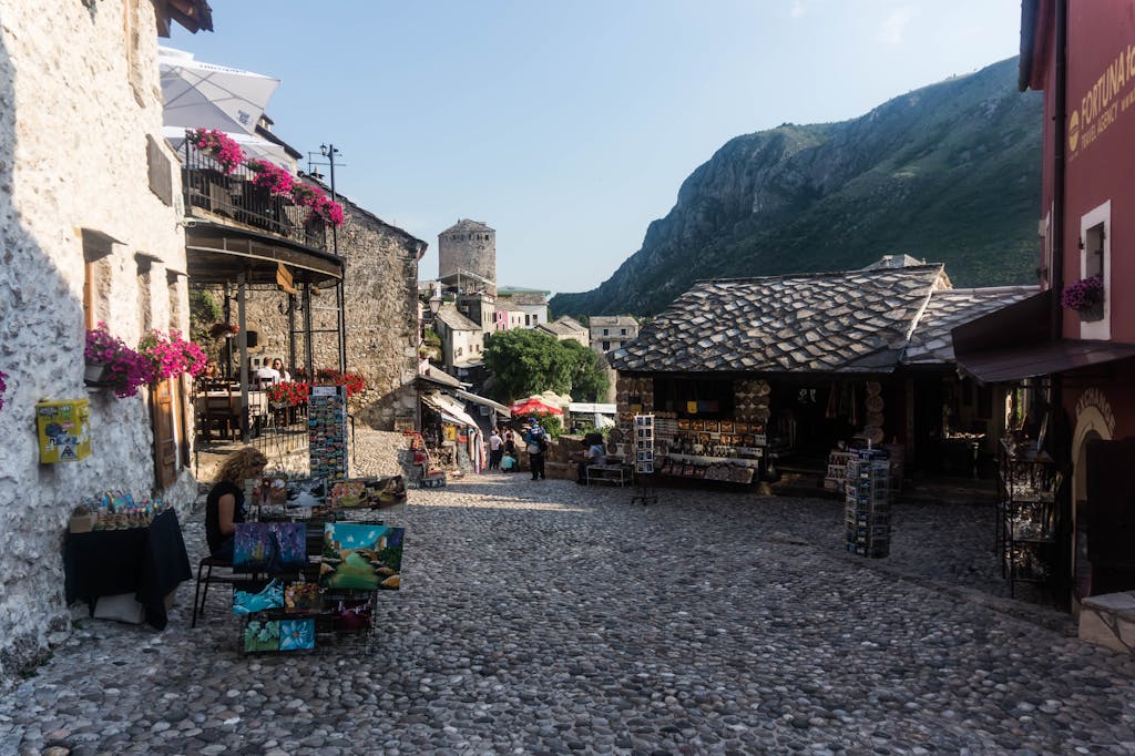 Picturesque street with cobblestones and vibrant flowers in a historic mountain town.