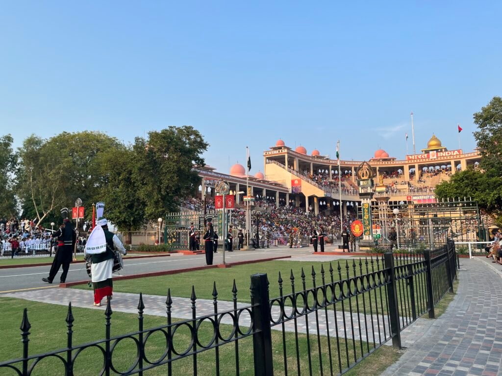 Pakistani and Indian soldiers perform high kicks and dramatic marching during the Wagah Border ceremony as crowds cheer from both sides. The energetic atmosphere shows one of the most unique and intense things to do in Lahore.