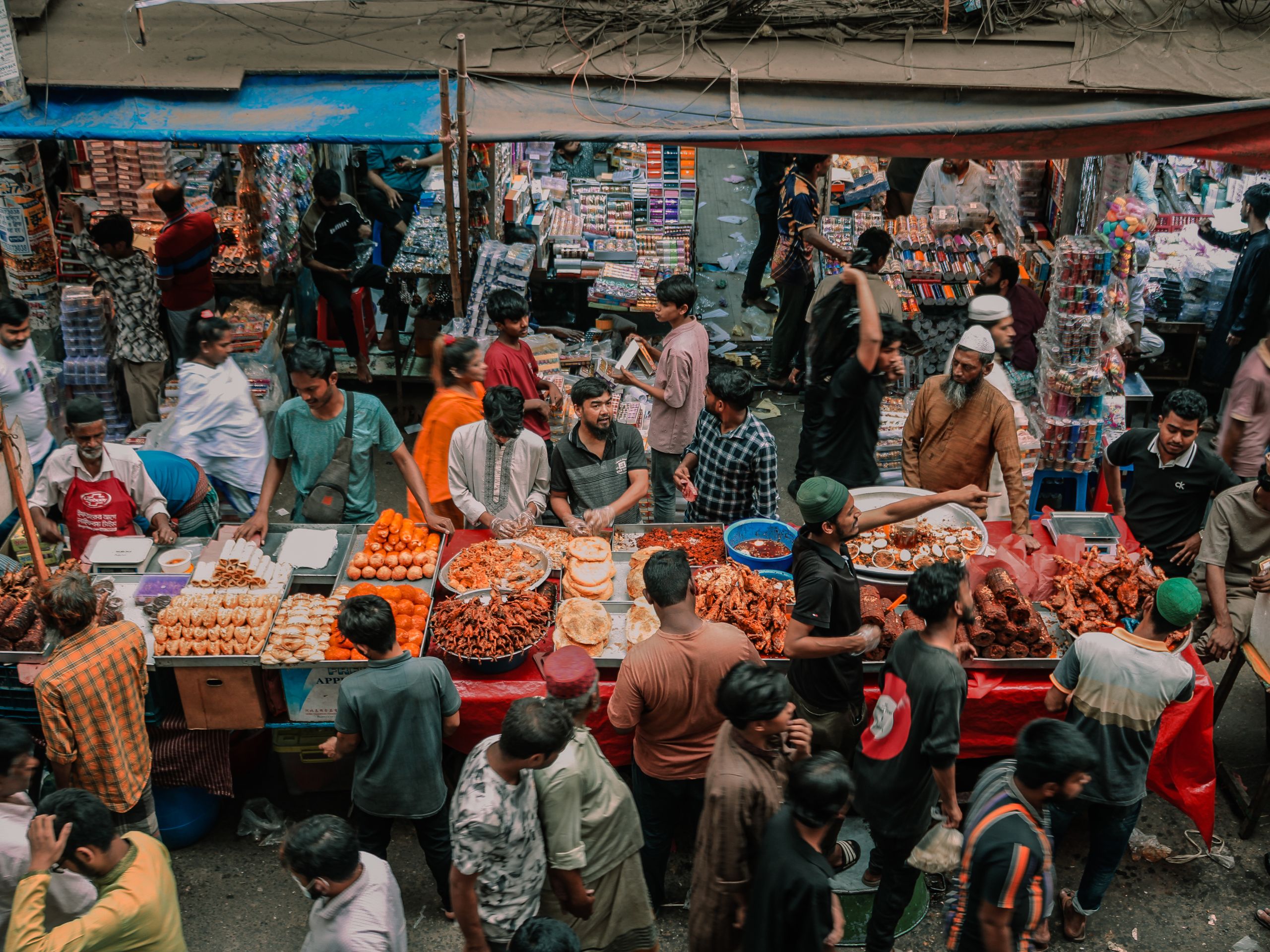 Vibrant street market filled with people and diverse street food stalls, capturing local culture.