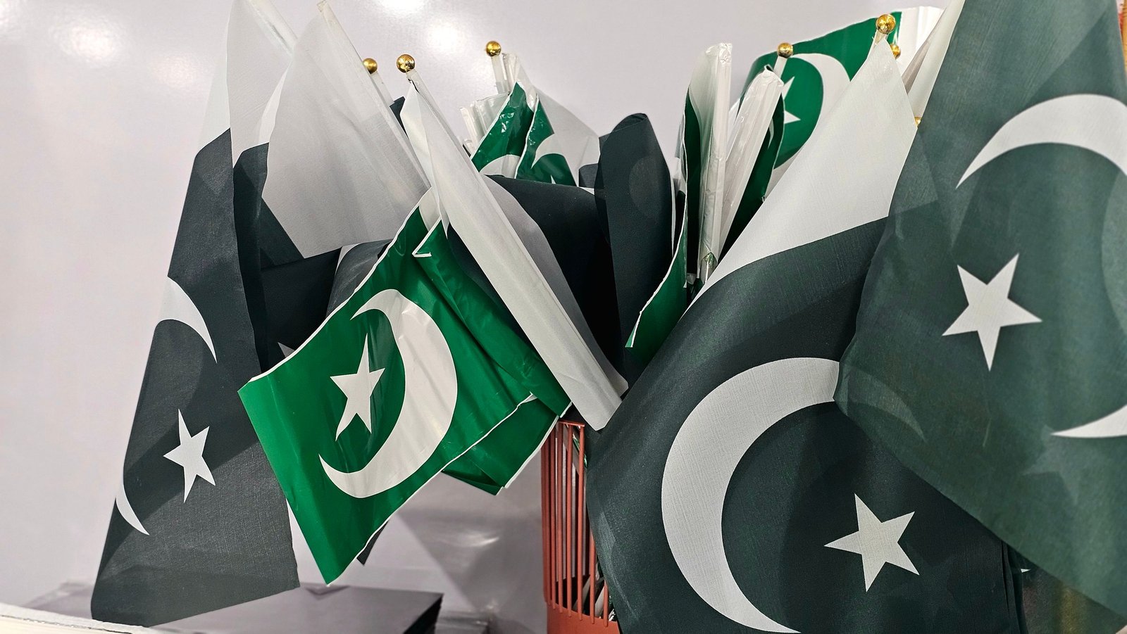 A variety of Pakistani flags grouped together indoors, emphasizing national pride to encourage visa for Pakistan